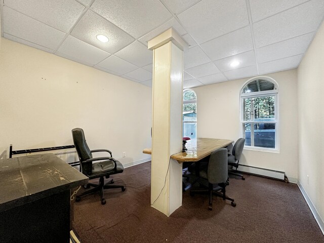 carpeted office space featuring a paneled ceiling and baseboard heating