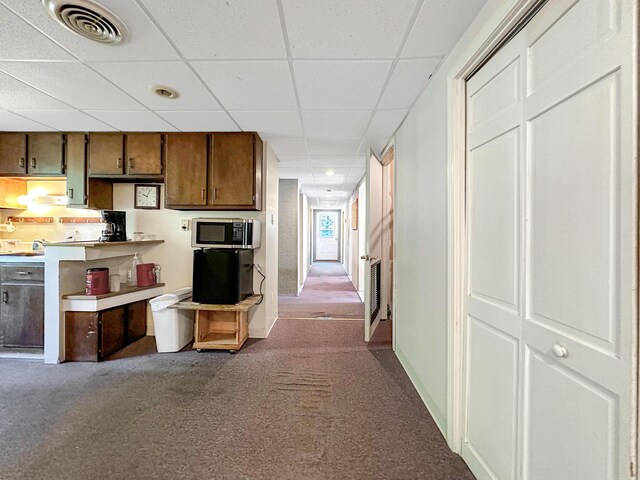 kitchen featuring a drop ceiling and carpet flooring