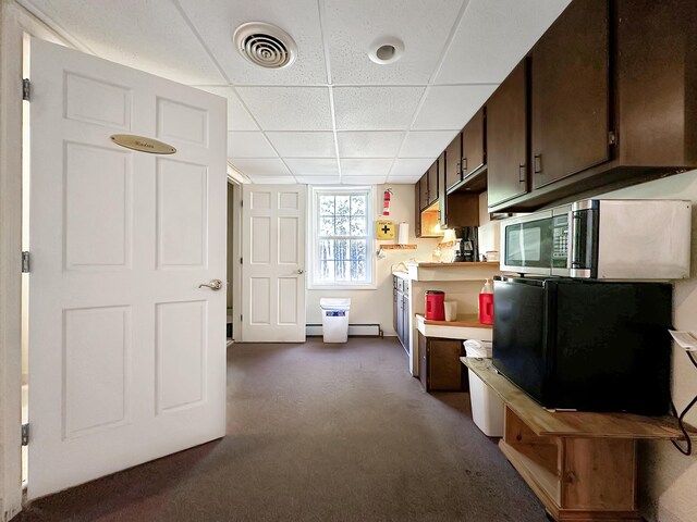 kitchen with dark brown cabinetry, black fridge, a paneled ceiling, and dark carpet