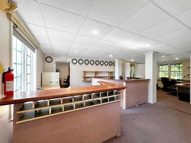 kitchen featuring a drop ceiling, decorative columns, carpet flooring, and a healthy amount of sunlight