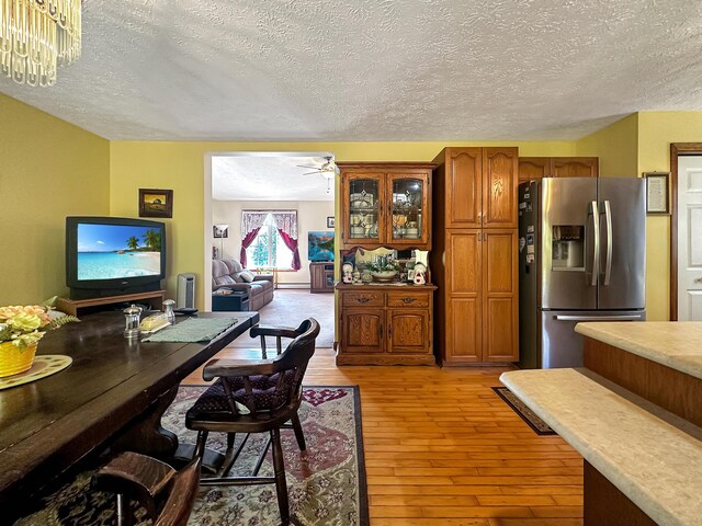 office featuring a textured ceiling, light wood-type flooring, and a notable chandelier