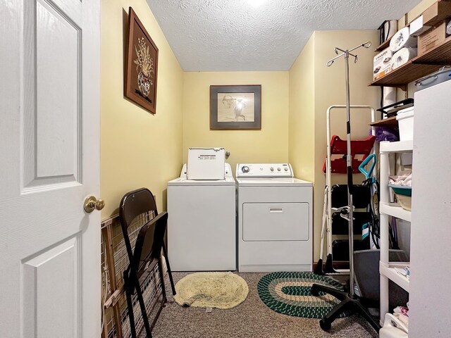 laundry area with a textured ceiling, carpet flooring, and washer and clothes dryer