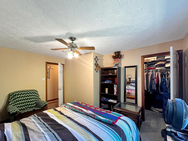 carpeted bedroom with ceiling fan, a textured ceiling, and a closet