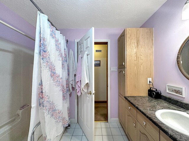 bathroom with a textured ceiling, tile patterned flooring, vanity, and a shower with shower curtain