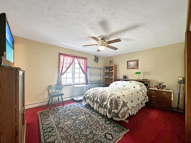 bedroom featuring a textured ceiling, baseboard heating, dark colored carpet, and ceiling fan