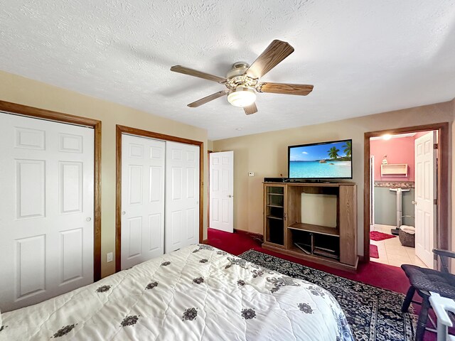 bedroom featuring connected bathroom, ceiling fan, tile patterned floors, and a textured ceiling