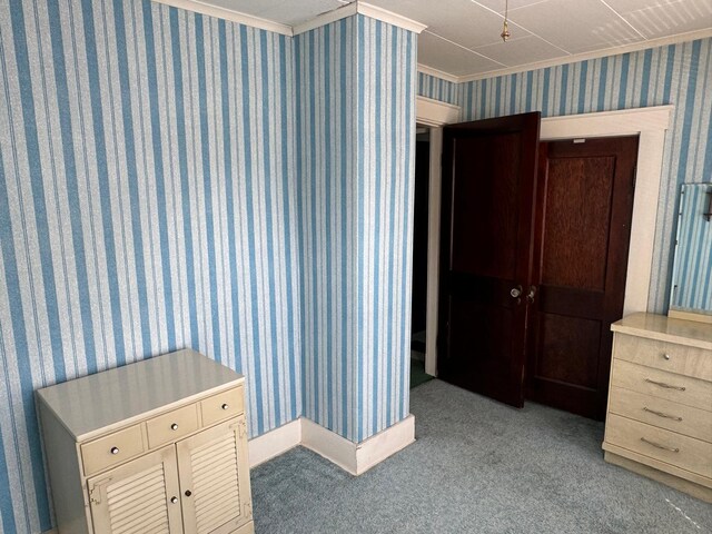 bedroom with ornamental molding and light colored carpet