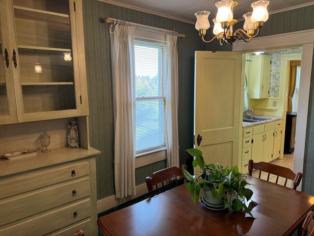 dining room with a chandelier, crown molding, and sink