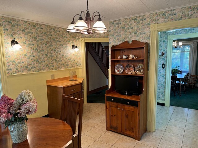 tiled dining area with a notable chandelier and crown molding