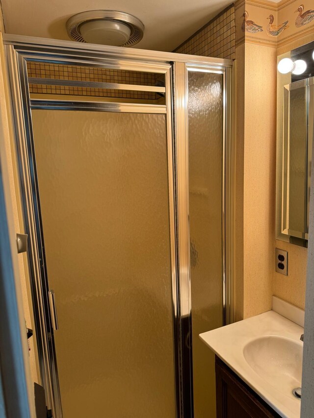 bathroom featuring vanity and a shower with shower door