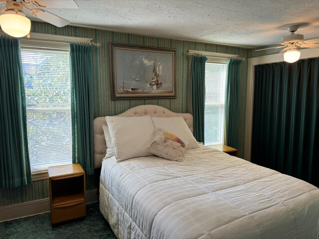 bedroom with a textured ceiling, ceiling fan, and carpet flooring