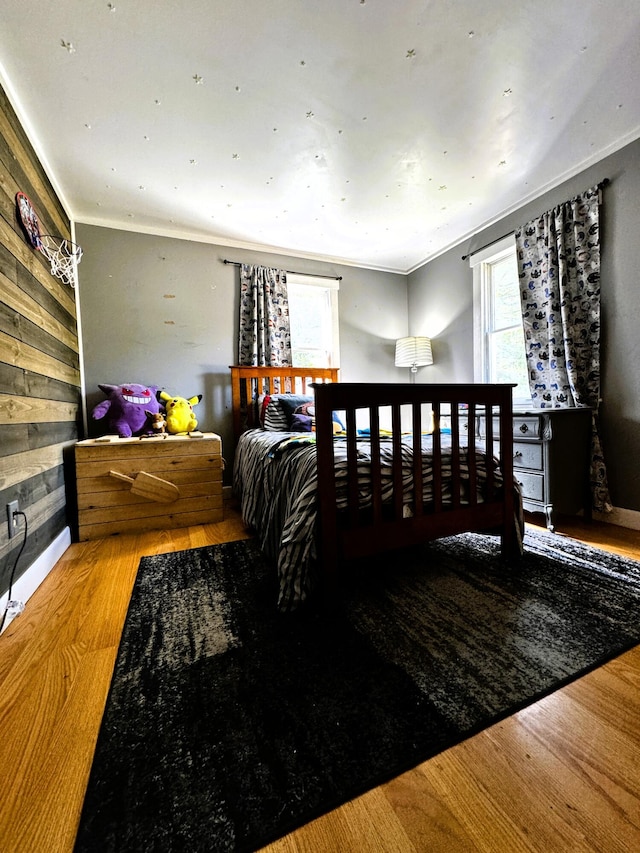 bedroom featuring hardwood / wood-style flooring and crown molding