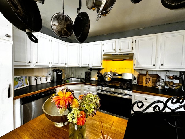 kitchen with backsplash, white cabinetry, appliances with stainless steel finishes, and sink