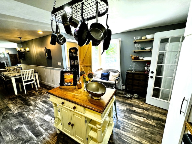 kitchen with dark hardwood / wood-style floors, butcher block counters, and a notable chandelier