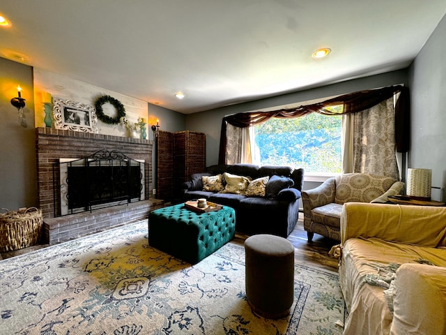 living room with hardwood / wood-style floors and a brick fireplace