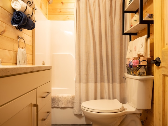 bathroom featuring vanity, wood walls, and toilet