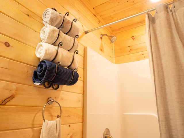 bathroom featuring wooden walls and wood ceiling