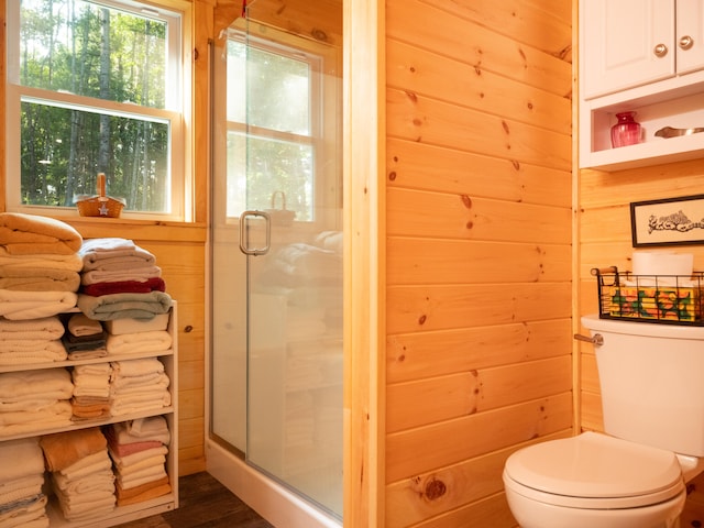 bathroom featuring an enclosed shower, wooden walls, hardwood / wood-style floors, and toilet