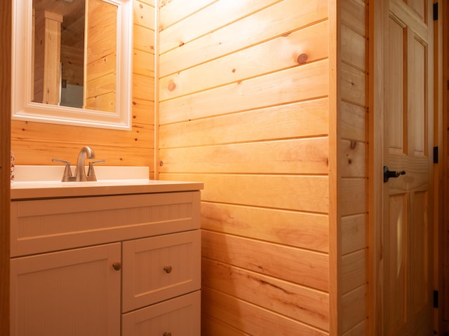 bathroom with vanity and wood walls