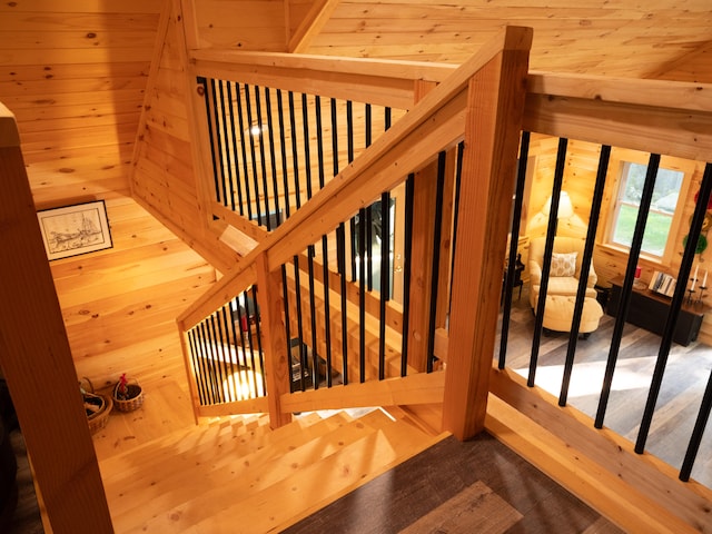 staircase featuring wooden walls and hardwood / wood-style floors