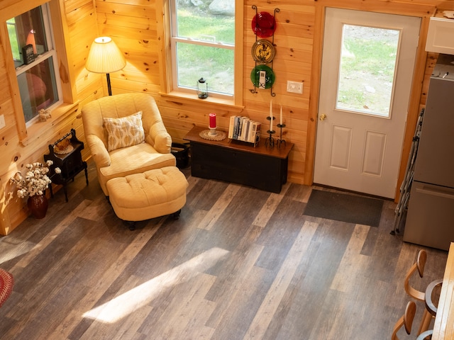 living area with wood walls and dark hardwood / wood-style flooring