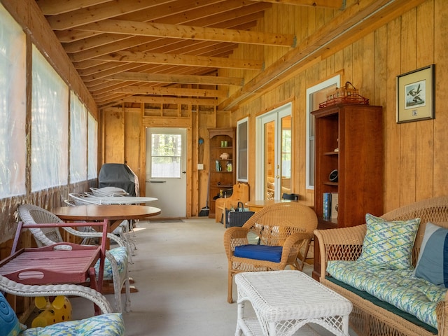 interior space with lofted ceiling, wood walls, and french doors