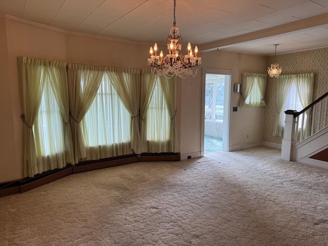 carpeted spare room with a notable chandelier and crown molding