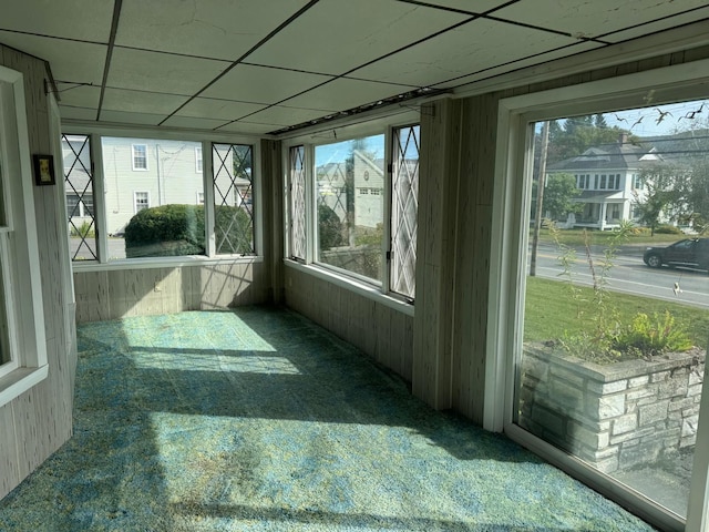 unfurnished sunroom featuring a paneled ceiling and a wealth of natural light