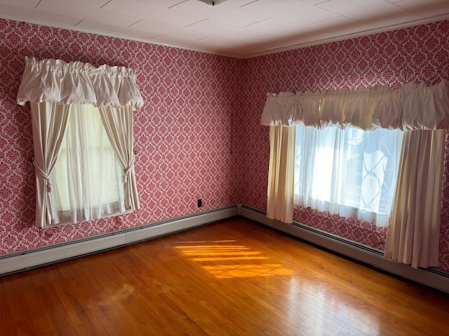 unfurnished room featuring hardwood / wood-style flooring, a healthy amount of sunlight, and crown molding