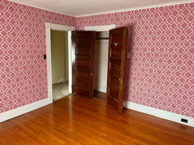 unfurnished room with ornamental molding and hardwood / wood-style floors