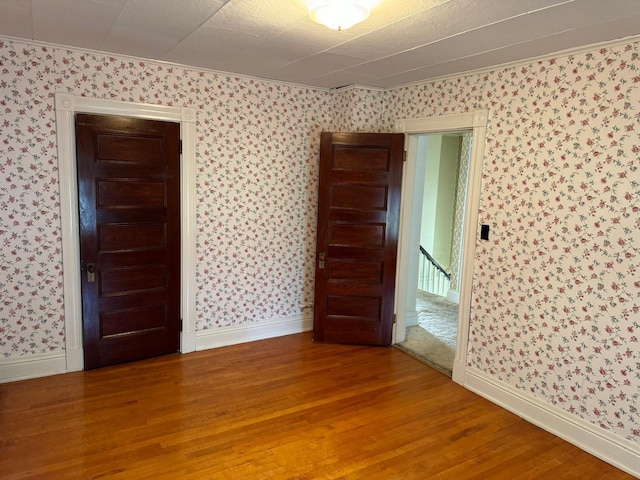 unfurnished room with wood-type flooring and crown molding