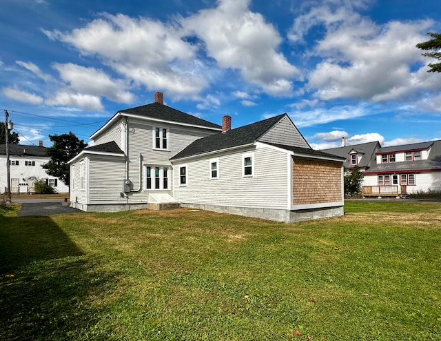 rear view of house featuring a lawn