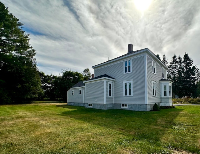 view of property exterior featuring a lawn and a chimney