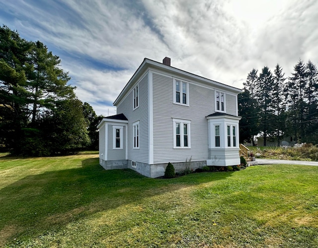 view of home's exterior with a lawn and a chimney