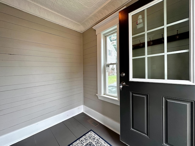 interior space featuring visible vents, baseboards, and wood walls