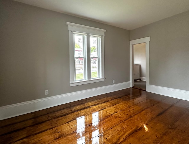 empty room with baseboards and dark wood-style flooring