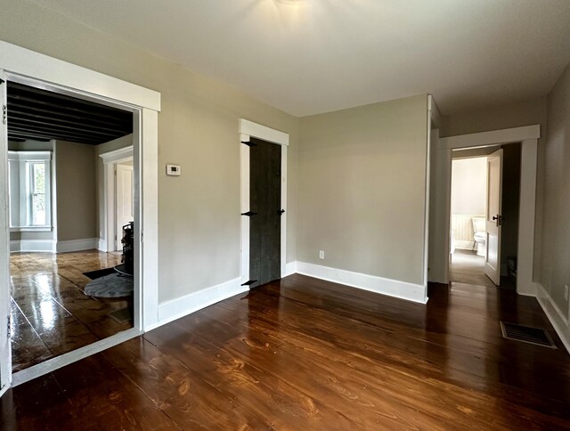 spare room with visible vents, baseboards, and wood finished floors