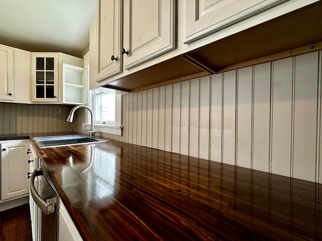 kitchen featuring white cabinetry, dishwasher, dark hardwood / wood-style flooring, wooden counters, and sink