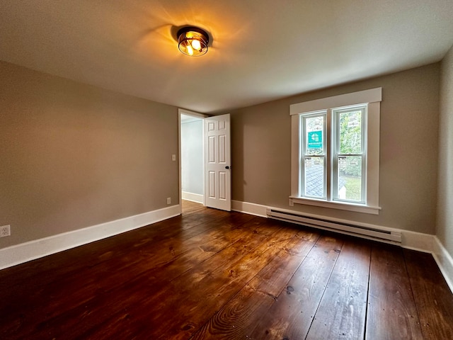 spare room featuring wood-type flooring, baseboards, and baseboard heating