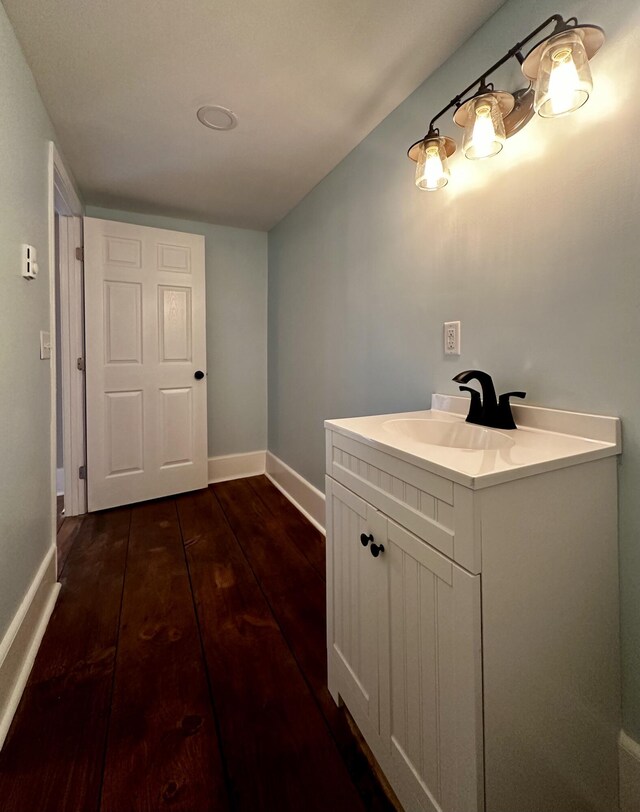 bathroom with vanity, baseboards, and wood finished floors