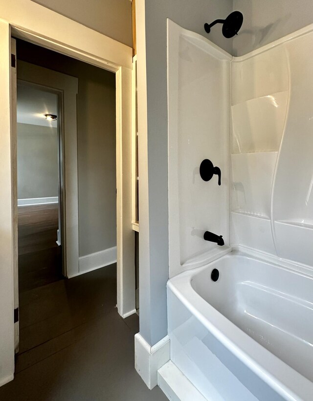 full bath with baseboards, shower / tub combination, and wood finished floors