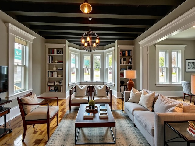 112 S St, Calais, ME 04619 - sitting room with a chandelier, wood finished floors, baseboards, and beamed ceiling