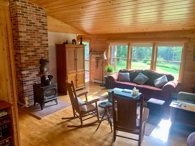 living room featuring light hardwood / wood-style floors, lofted ceiling, a baseboard heating unit, and a wealth of natural light