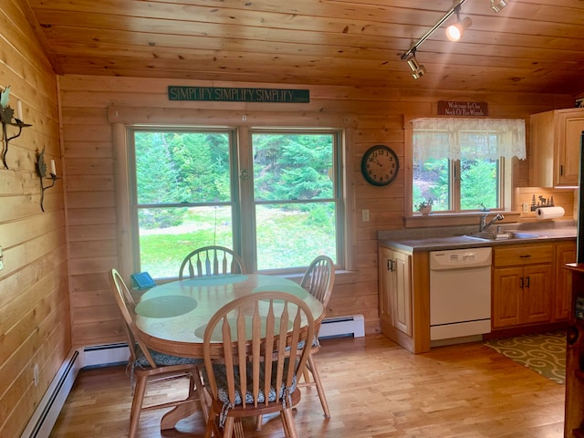 dining room with wood walls, light hardwood / wood-style floors, and sink