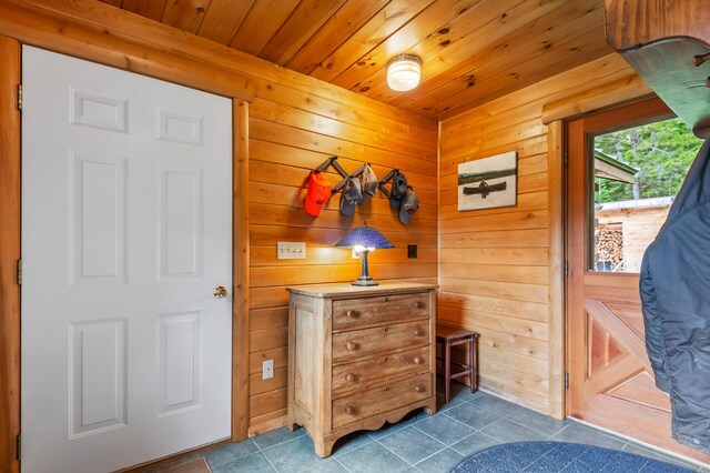 62 Antler Way, Rangeley, ME 04970 - foyer entrance with dark tile patterned flooring, wood ceiling, and wooden walls