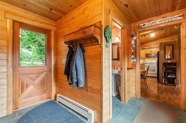 62 Antler Way, Rangeley, ME 04970 - doorway featuring a baseboard radiator, wood ceiling, dark tile patterned flooring, lofted ceiling, and wood walls