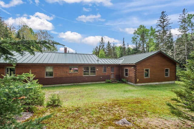 62 Antler Way, Rangeley, ME 04970 - rear view of house featuring a standing seam roof, metal roof, entry steps, log exterior, and a lawn