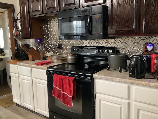 kitchen with dark brown cabinetry, backsplash, white cabinetry, black appliances, and light wood-type flooring