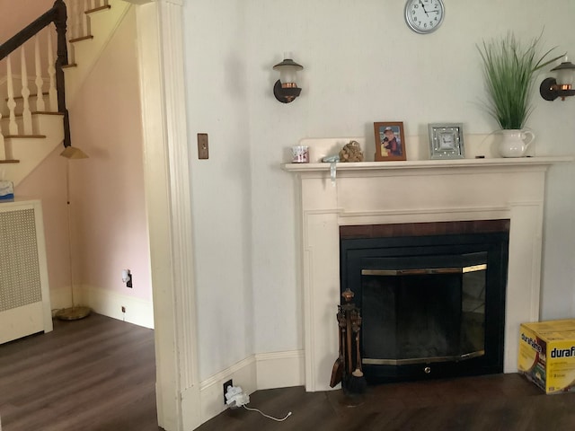 interior details with wood-type flooring, radiator heating unit, and a tile fireplace