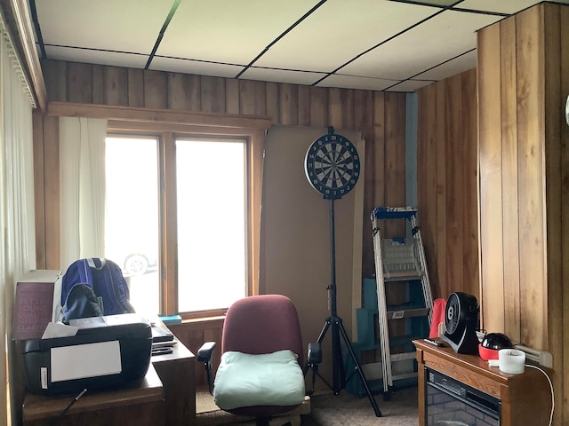 office area featuring carpet floors, wooden walls, and a paneled ceiling